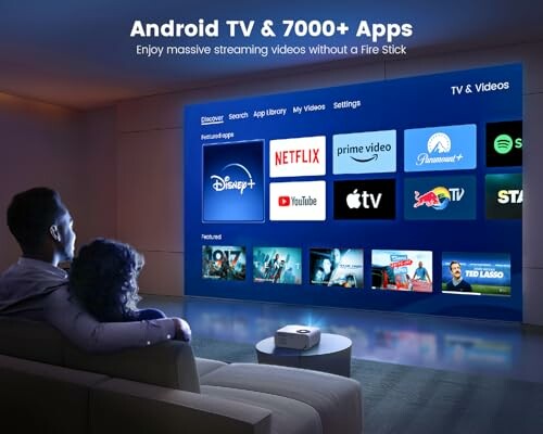 Couple watching TV with streaming app icons on screen.