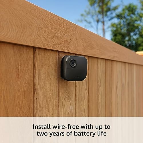 Wire-free security camera installed on wooden fence.